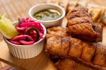 Chicharrones y carnita de cerdo con curtido, limón  y salsa de cilantro