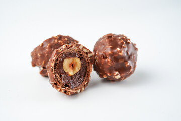 Sweet chocolate balls is made. Chocolate candy in gold wrapper on white background