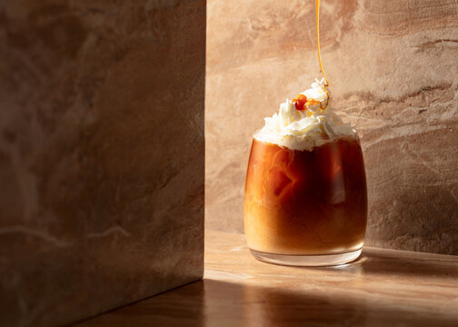 Iced caramel latte topped with whipped cream and caramel sauce.