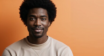 Fototapeta premium Young Black man with dimples neutral face light orange background