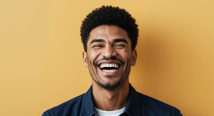 Obraz premium Young mixed race man with angular jawline laughing warm yellow background