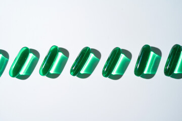 Vitamin E softgel capsules, vitamin D3, fish oil, omega 3, Green oil pills on a white background