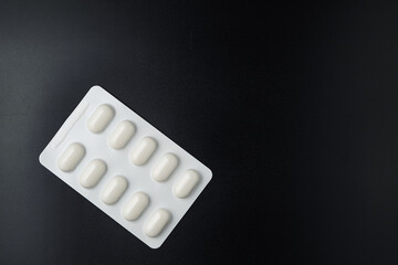 Tablet pills blister Medicine capsules on a black background