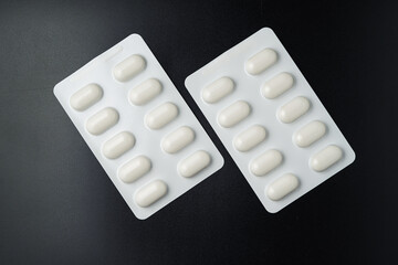 Tablet pills blister Medicine capsules on a black background