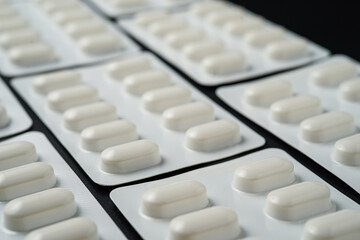 Pills Medicine tablet capsules in blister pack on a black background