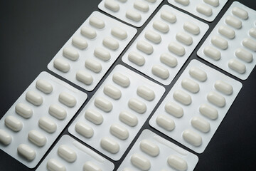 Pills Medicine tablet capsules in blister pack on a black background