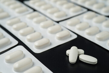 Pills Medicine tablet capsules in blister pack on a black background