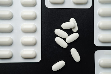 Pills Medicine tablet capsules in blister pack on a black background