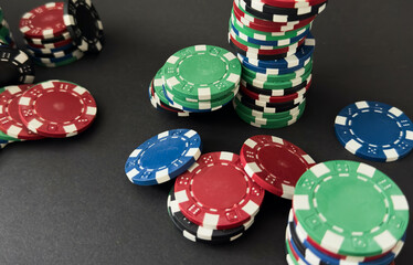 Colorful different value poker chips on black casino table, win after game. Concept of hazard gaming