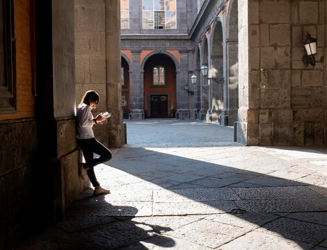 Tourist woman reading guide book in city
