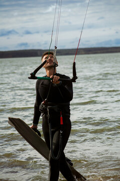 A mid adult man heads out for kitesurfing.