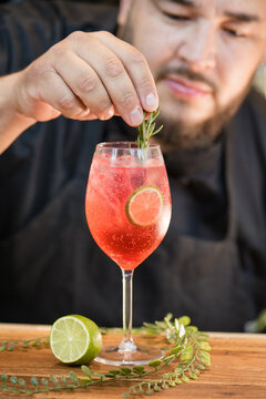 Male chef garnishing a pink drink