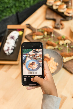 Woman taking a photo of a display of foods