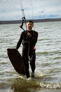 A mid adult man heads out for kitesurfing.