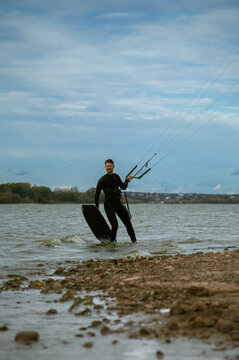 Middle aged man kite surfing, holding a bar in his hands.