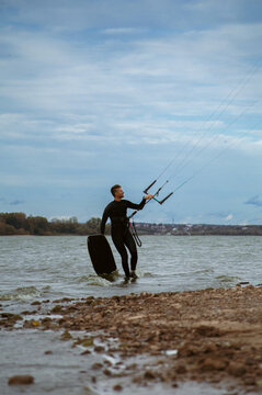 Middle aged man kite surfing, holding a bar in his hands.