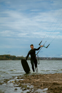 Middle aged man kite surfing, holding a bar in his hands.