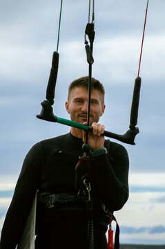 Middle aged man kite surfing, holding a bar in his hands.