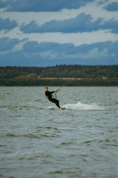A mid adult man kitesurfs the lake.