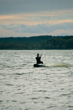 A mid adult man holds on tight while kitesurfing.