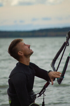 Middle aged man kite surfing, holding a bar in his hands.