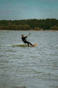 A mid adult man kitesurfs the lake.