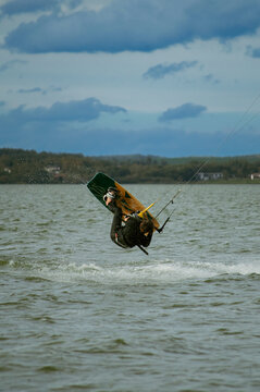 Man do tricks with his board practicising kitesurf jump in the air.