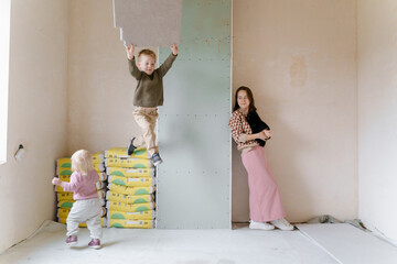 A young woman with a cat and two children in an empty house