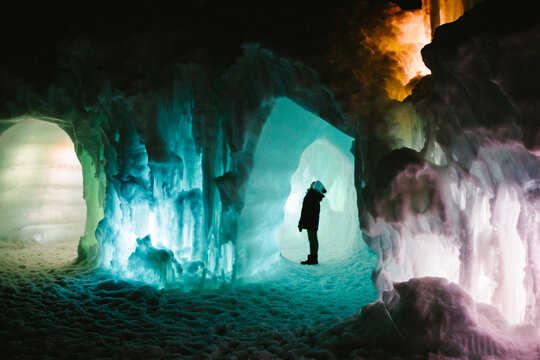 Small person inside large ice and snow tunnel and cave