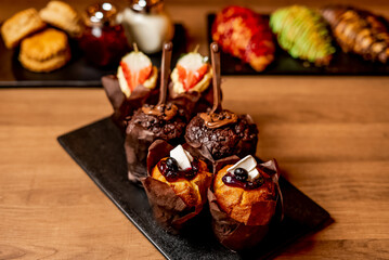 Muffin cup cakes on black cutting board and wooden background 