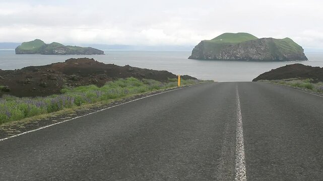 Beautiful down road in the Westman Islands, Iceland. Two isolated and uninhabited islands in the background, Ellidaey and Bjarnarey.