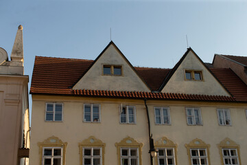 There is a large white building that features a distinctive red tiled roof, standing out in its surroundings and capturing attention