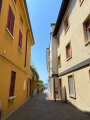 Fototapeta premium A pleasant walk through the quiet narrow streets of an Italian town under the shadow of the ancient buildings surrounding them.