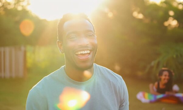 Zambian Man Laughing with Friends at a Park Picnic