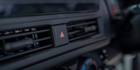 Obraz premium emergency button in car dashboard,hazard flasher switch or emergency light button in modern car, shallow depth of field.