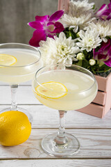 Yellow cocktail with a slice of lemon on a light background