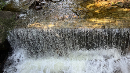A small mountain river with a flow of water in the Polish mountains. Eastern Sudetes