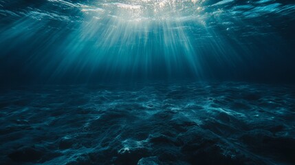 The deep blue ocean surface is visible from beneath the waves. Sunlight streams down, creating a beautiful underwater scene.  The seafloor is dimly lit in the distance.