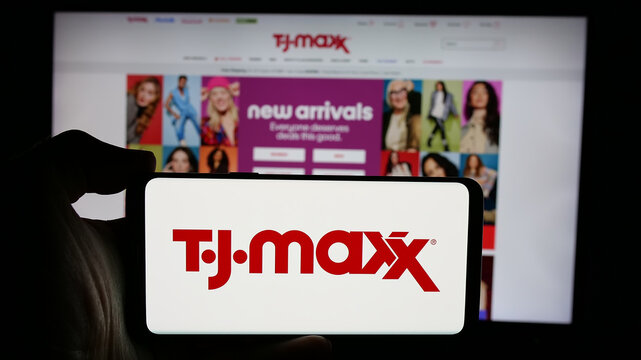 Stuttgart, Germany - 10-04-2024: Person holding cellphone with logo of American discount department store company TJ Maxx on screen in front of webpage. Focus on phone display.