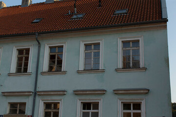 A charming bluecolored building features a vibrant red tile roof that adds a delightful contrast to its overall exterior appearance