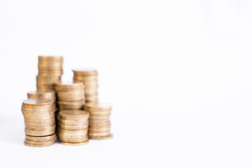 defocused stacks of golden coins isolated on white background with copy space, abstract backdrop
