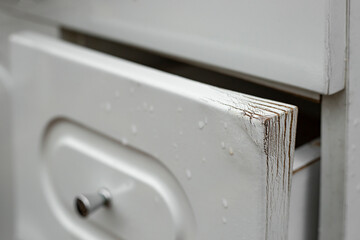 Water Damaged door from bathroom furniture, soft focus close up