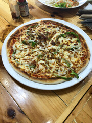 Pizza on the wooden table in the restaurant. Pizza on the wooden table