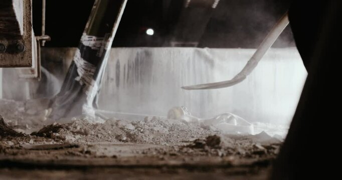 Bauarbeiter verteilt Schutt mit Schippe in der Dunkelheit