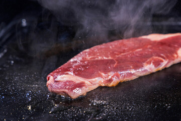生の牛肉を鉄板で焼く様子