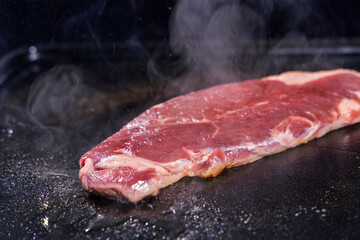 生の牛肉を鉄板で焼く様子