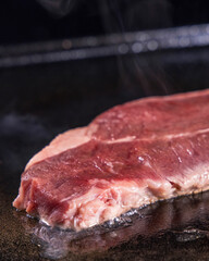 生の牛肉を鉄板で焼く様子