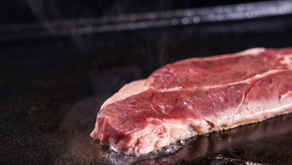 生の牛肉を鉄板で焼く様子
