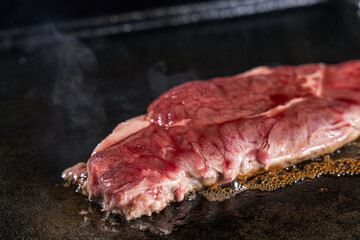 生の牛肉を鉄板で焼く様子