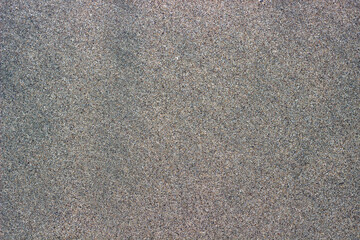 Sea sand background. Volcanic sand.

